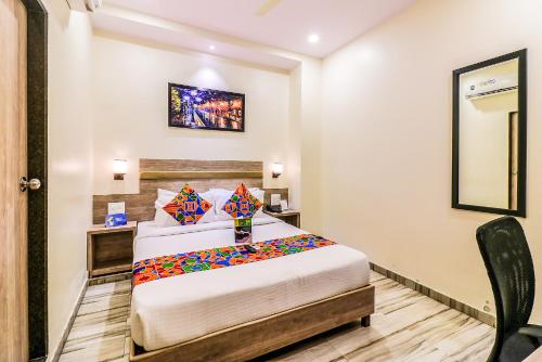 a hotel room with a bed and a chair at FabHotel Aksa International Andheri East in Mumbai