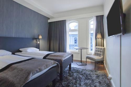 a hotel room with two beds and a television at K7 Hotel Oslo in Oslo