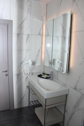 ein weißes Badezimmer mit Waschbecken und Spiegel in der Unterkunft Anka Premium Hotel in Istanbul