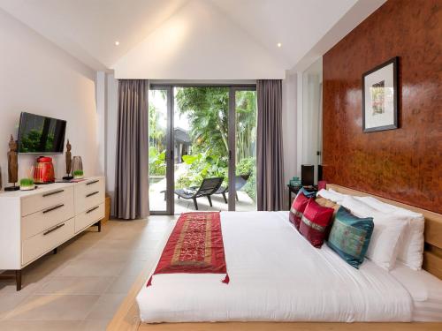 a bedroom with a large white bed and a television at Infinity Blue Phuket by Elite Havens in Natai Beach
