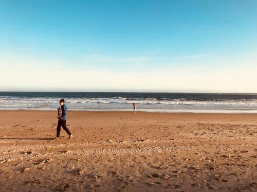 a man walking on the beach near the ocean at Beautiful, Cosy and Quiet in Cape Paterson