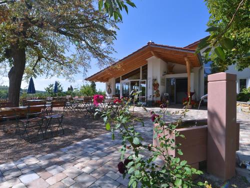 une maison avec des chaises, des tables et une terrasse dans l'établissement Am Paradies, à Müllheim