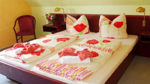 Dos camas con toallas y corazones. en Pension Am Bodden, en Ribnitz-Damgarten