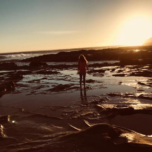 a woman standing on the beach at sunset at Beautiful, Cosy and Quiet in Cape Paterson