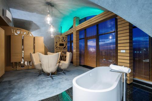布拉格Wellness Hotel Step - Czech Leading Hotels的带浴缸和桌椅的浴室