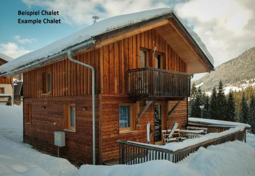 a log cabin with a balcony in the snow at Alpendorf Dachstein West by ALPS RESORTS in Annaberg im Lammertal
