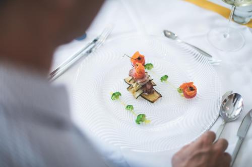 a white plate with food on a table at Hotel Fameli in Valdaora