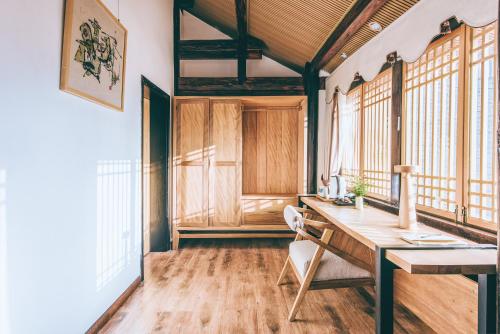 an office with a wooden desk in a room with windows at Dali Shaxi Qing Jing Courtyard in Jianchuan