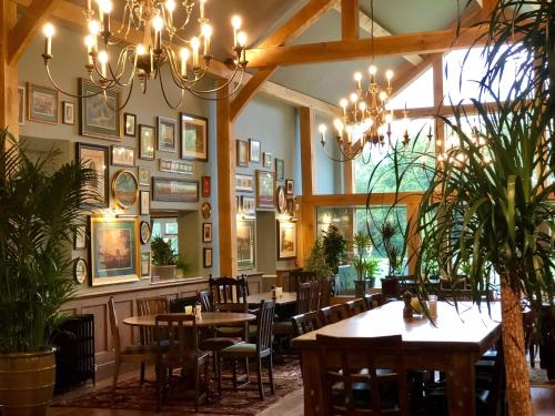 a restaurant with tables and chairs and a chandelier at Arrow Mill- Brunning and Price in Alcester