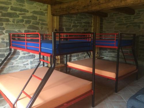 two bunk beds in a room with a stone wall at gite l'entre 2 monts in Chaudeyrolles