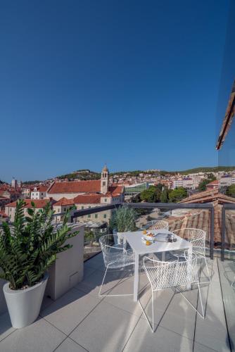 a white table and chairs on a balcony with a view at Bellevue Superior City Hotel in Šibenik