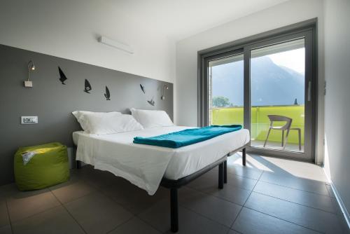 a bedroom with a bed and a large window at Residence Centro Vela in Riva del Garda