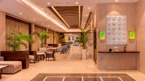 Lemon Tree Hotel Lucknow في لاكناو: لوبي مطعم فيه طاولات وكراسي