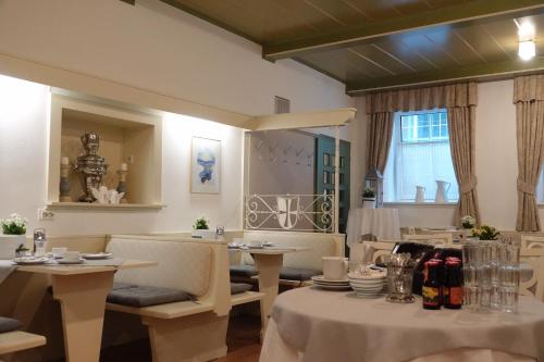 a dining room with tables and chairs and a window at Gasthof "Zur Kanne" in Sankt Florian bei Linz