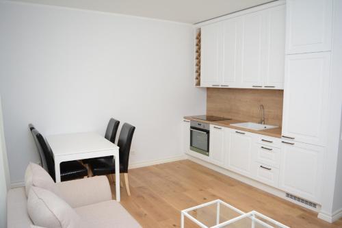 a kitchen with white cabinets and a table and chairs at Koidula Villa in Pärnu