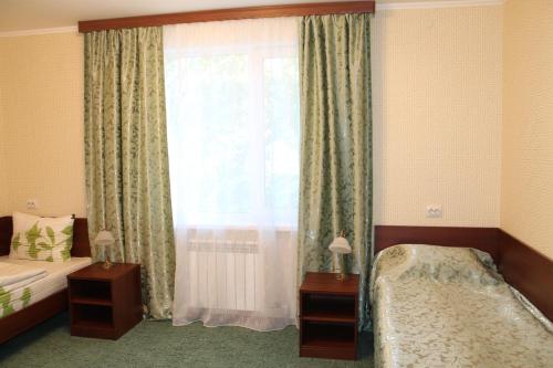 a bedroom with a bed and a window at Hotel Red Dog in Gorno-Altaysk