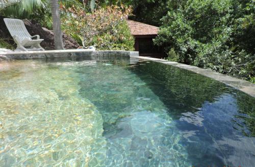 a pool of clear water with a chair in it at Bois Joli in Mahe