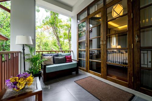 a screened in porch with a bench and a table at Villa Klang Wiang in Chiang Mai