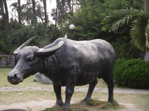 a statue of a bull standing in the grass at Chong Er Ya She Homestay in Jiji