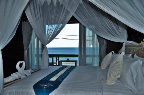 a bedroom with a bed with a view of the ocean at Ocean Terrace Suite And Spa Luxury in Nusa Penida