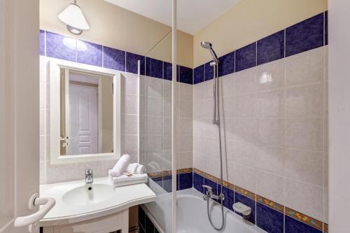 une salle de bain avec un lavabo et une douche dans l'établissement Residence Le Hameau de la Pinede - maeva Home, à Hyères