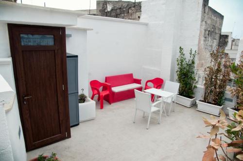 a patio with red and white chairs and a table at B & B Sotto la Volta in Massafra