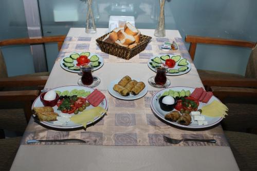 una mesa con cuatro platos de comida. en Anka Premium Hotel en Estambul