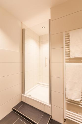 a shower with a glass door in a bathroom at Haus am See B&B in Bornheim