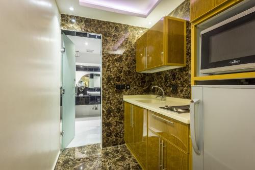 a small kitchen with a sink and a refrigerator at Al Muhaidb Takhasosi Value in Riyadh
