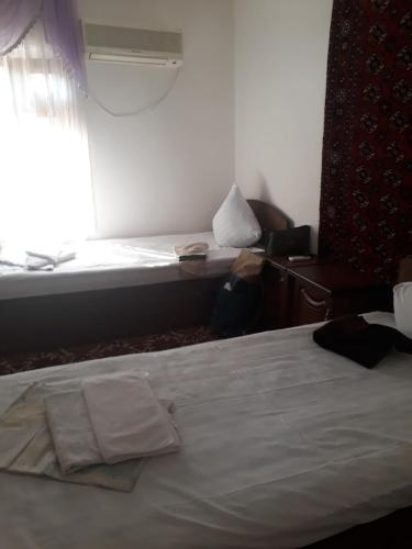 a hotel room with a bed and a window at Hotel Nazira & Azizbek in Bukhara
