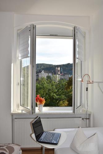 a laptop sitting on a table in front of a window at Pension Vila Hana in Loket