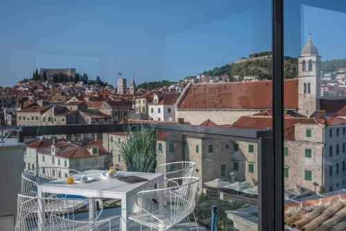 a table and chairs on a balcony overlooking a city at Bellevue Superior City Hotel in Šibenik