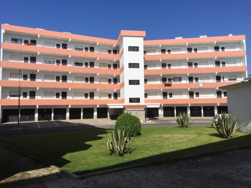 an apartment building with a green lawn in front of it at Apartamento Santa Cruz in Santa Cruz