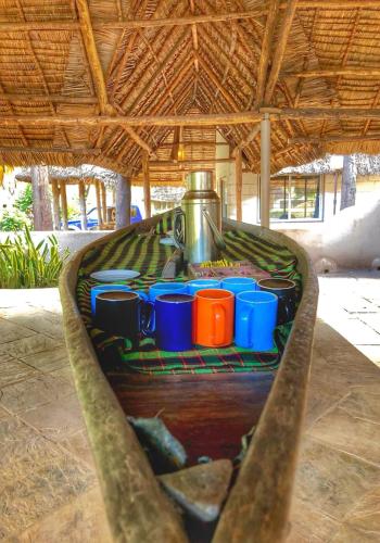 a table with cups and a pot on top at Honey Badger Lodge in Moshi