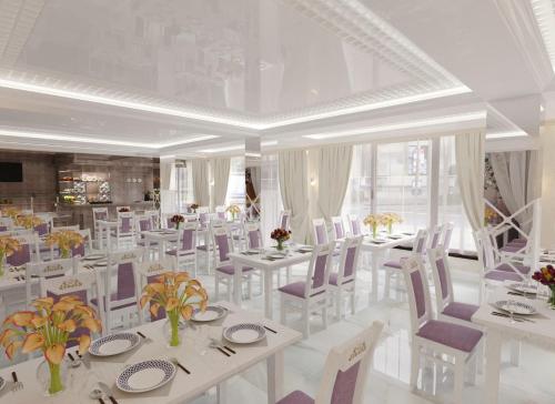 uma sala de jantar com mesas brancas e cadeiras brancas em Hotel Bellavista & Spa em Bukovel