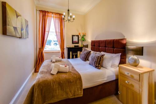 Un dormitorio con una cama grande y una ventana en ALTIDO Modern 3 bed flat, closeby the Meadows & Old Town en Edimburgo