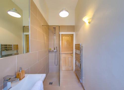 a bathroom with a shower and a sink and a mirror at ALTIDO Modern 3 bed flat, closeby the Meadows & Old Town in Edinburgh