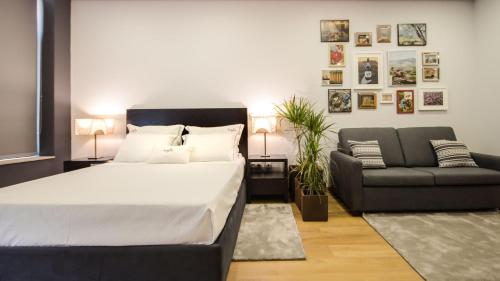 ペーゾ・ダ・レーグアにあるBugalha My Loft Douro 1のベッドルーム(大型ベッド1台、ソファ付)