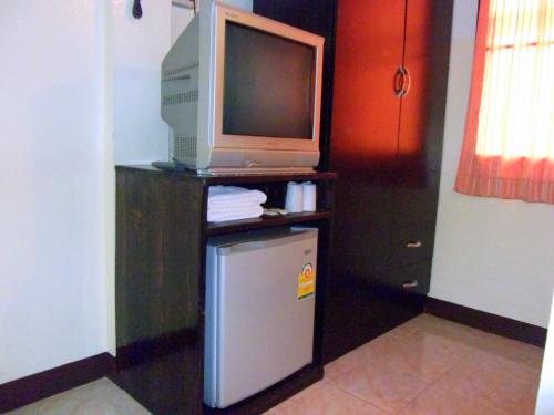 a television and a small refrigerator in a room at Lanna Thai Guesthouse in Chiang Mai