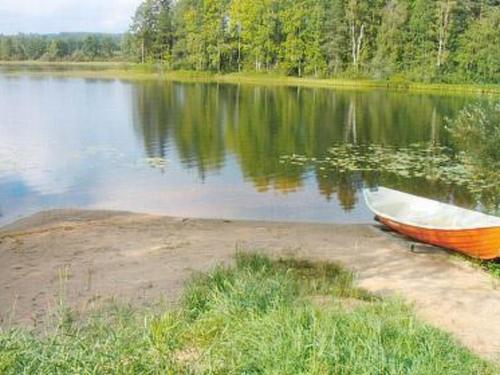 a boat sitting on the shore of a lake at Holiday Home Honkaharju by Interhome in Petäjävesi