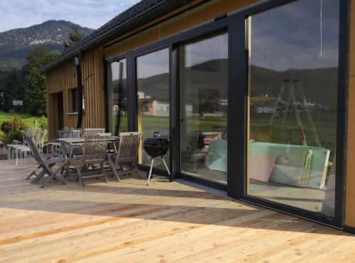 a screened porch with a table and chairs and windows at dasGams in Gosau