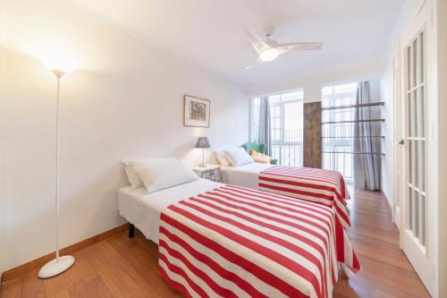 2 Betten in einem Zimmer mit weißen Wänden und Fenstern in der Unterkunft Apartamento En El Centro De Nerja in Nerja