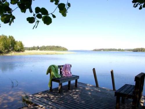 a bench sitting on a dock next to a body of water at Holiday Home Ylähuone by Interhome in Pätiälä