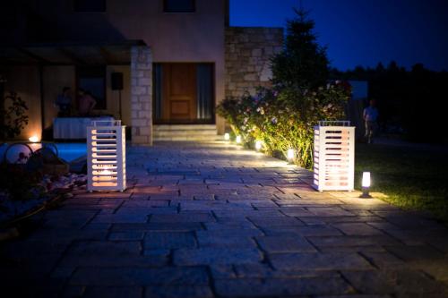 a patio with lights in front of a house at night at Mediterra retreat in Kapandrítion