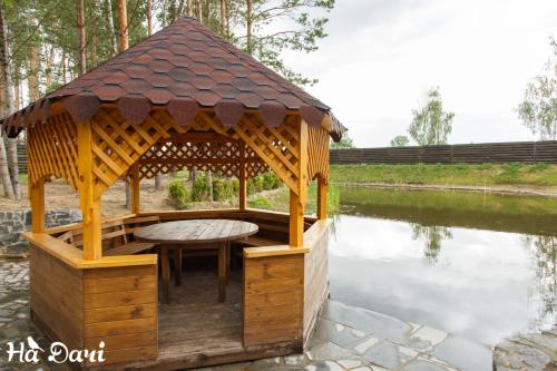 a gazebo with a table in the water at Комплекс На Дачі in Vyshpolʼ