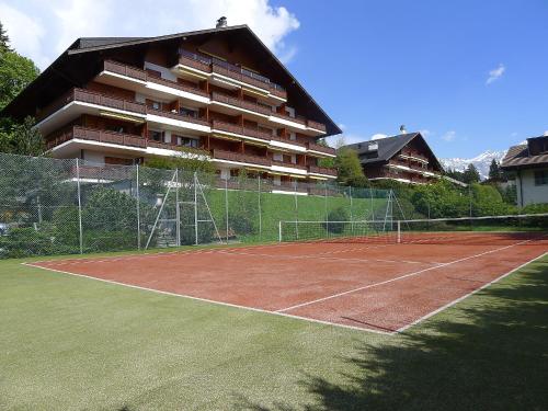 a tennis court in front of a building at Apartment Grand-Hôtel B35 by Interhome in Villars-sur-Ollon
