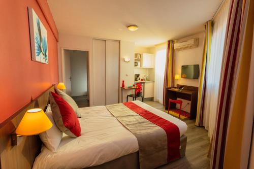 una camera d'albergo con letto e scrivania di Appart-Hôtel Mer & Golf City Perpignan Centre a Perpignano