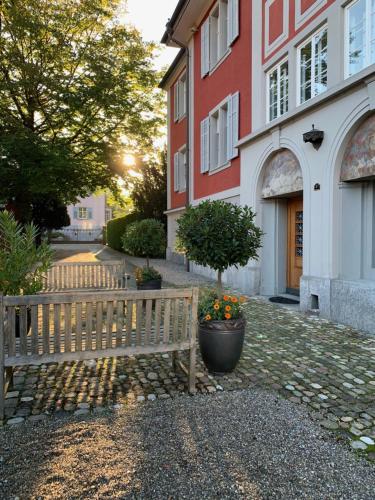a wooden bench sitting in front of a building at Villa Jakobsbrunnen in Winterthur