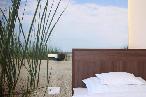 a bedroom with a bed and a wooden head board at Hotel Seelust in Cuxhaven