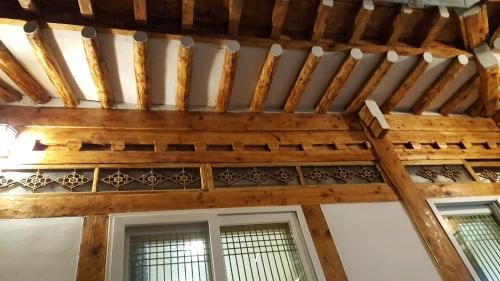 een kamer met een houten plafond en 2 ramen bij Hwangridangil Adamjeong in Gyeongju